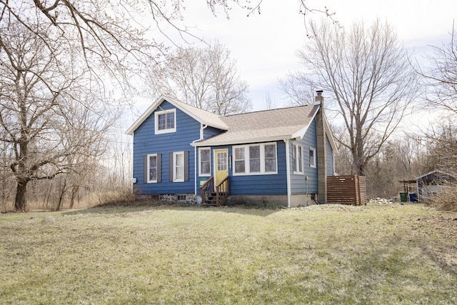 view of front of home with a front lawn, a chimney, entry steps, and a shingled roof