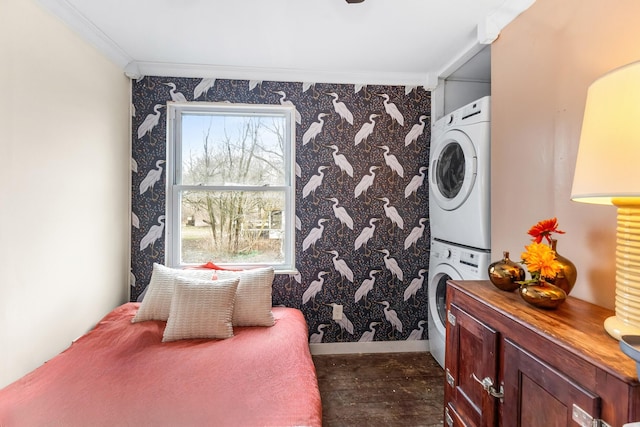 clothes washing area with wallpapered walls, crown molding, stacked washing maching and dryer, and laundry area