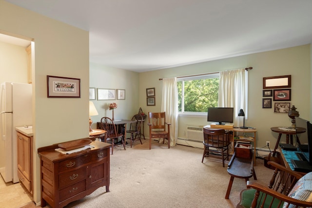 sitting room featuring a baseboard heating unit and light carpet