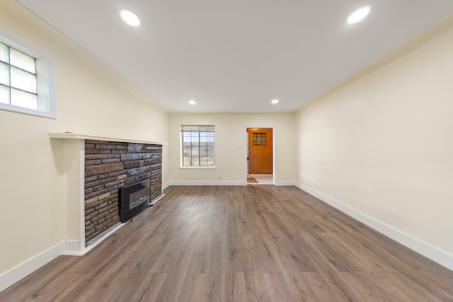 unfurnished living room featuring wood finished floors, a fireplace, and baseboards
