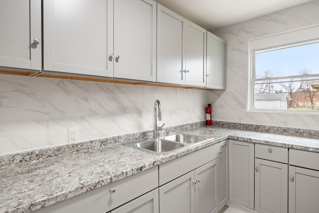 kitchen with white cabinets, a sink, and decorative backsplash