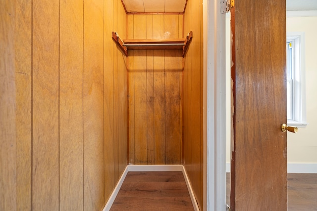 interior space featuring wood finished floors, wooden walls, and baseboards