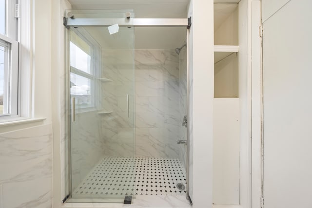 bathroom featuring a marble finish shower