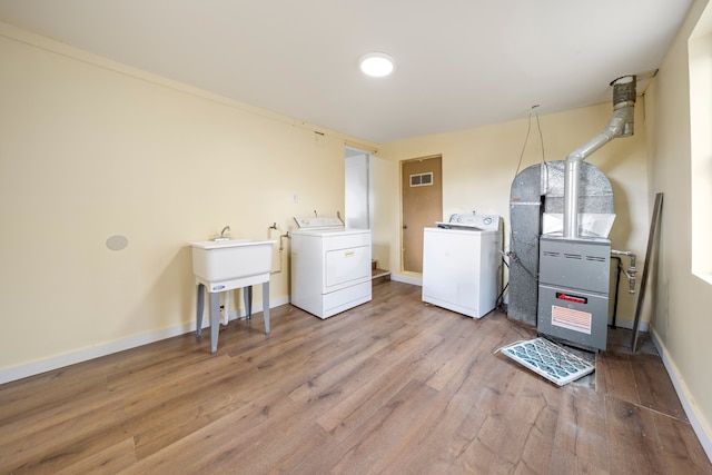 laundry room with light wood-type flooring, baseboards, visible vents, independent washer and dryer, and laundry area