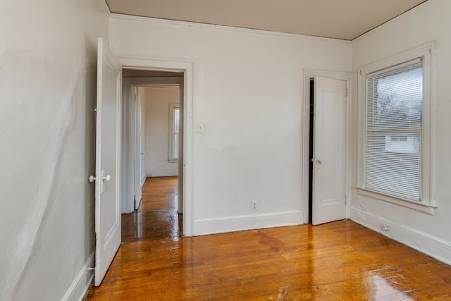 empty room featuring baseboards and hardwood / wood-style flooring