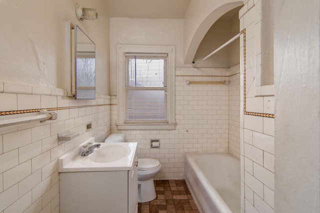 bathroom with toilet, vanity, shower / tub combination, and tile walls