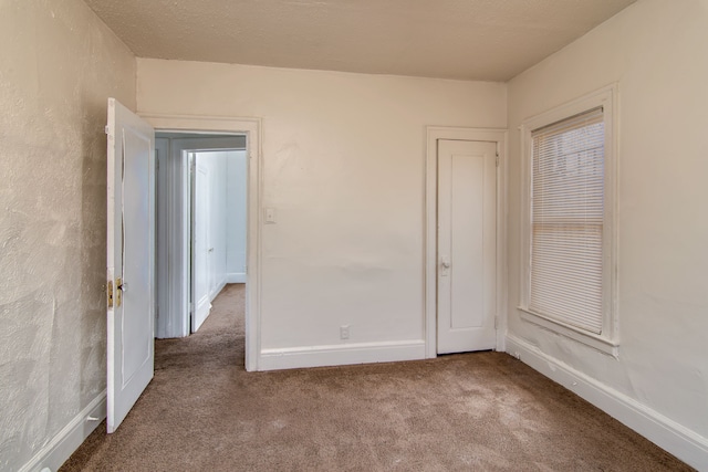 unfurnished room featuring carpet flooring and baseboards