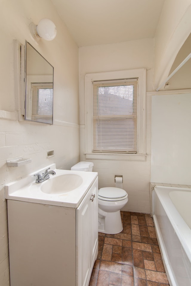 full bath featuring a bathing tub, toilet, and vanity