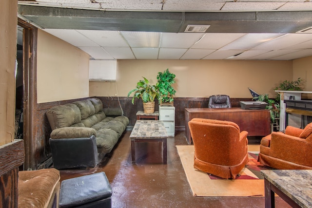 interior space with a drop ceiling, finished concrete flooring, and visible vents