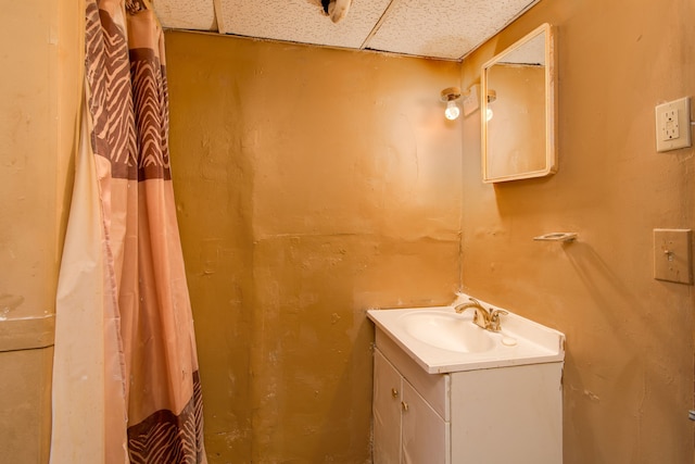 full bathroom featuring a drop ceiling, vanity, and curtained shower