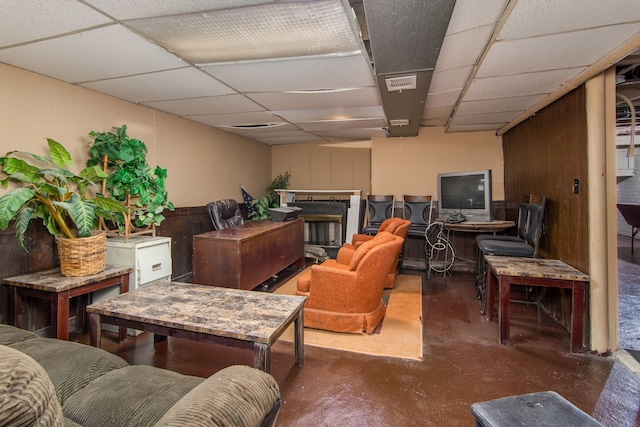 living area with visible vents, concrete floors, and a drop ceiling