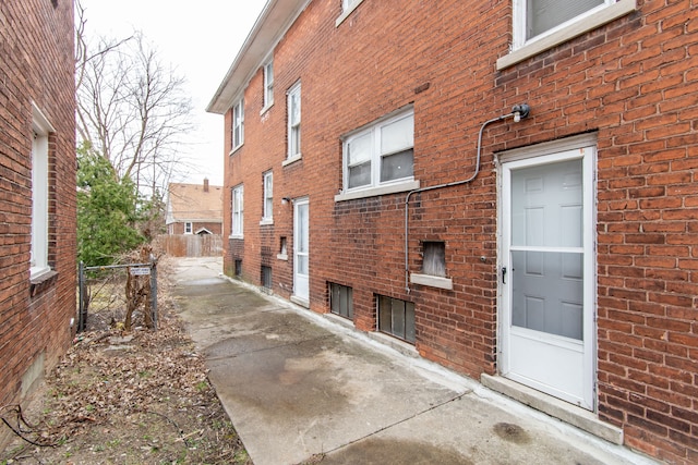 view of home's exterior featuring brick siding and fence