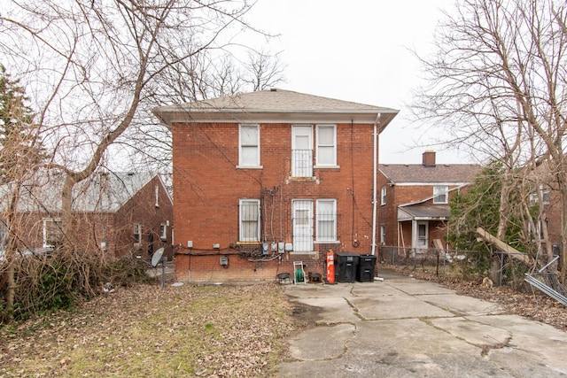 back of house with fence and brick siding