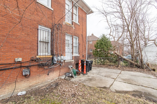 view of home's exterior featuring brick siding and fence