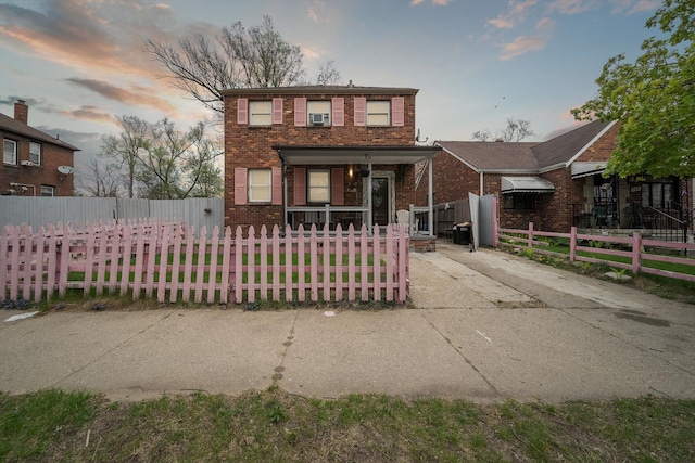 15032 Snowden St, Detroit, MI 48227 - traditional home featuring covered porch, concrete driveway, brick siding, and a fenced front yard