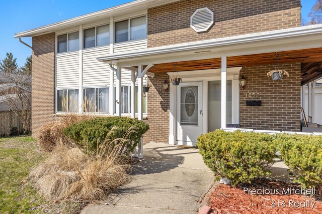 property entrance featuring brick siding and a porch