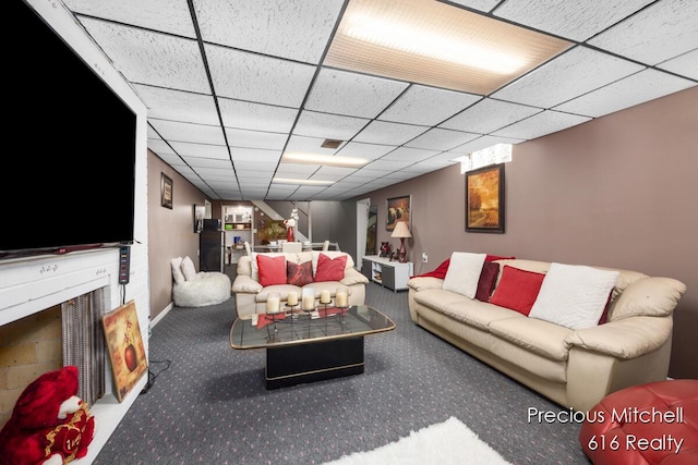 living room featuring a drop ceiling and carpet flooring