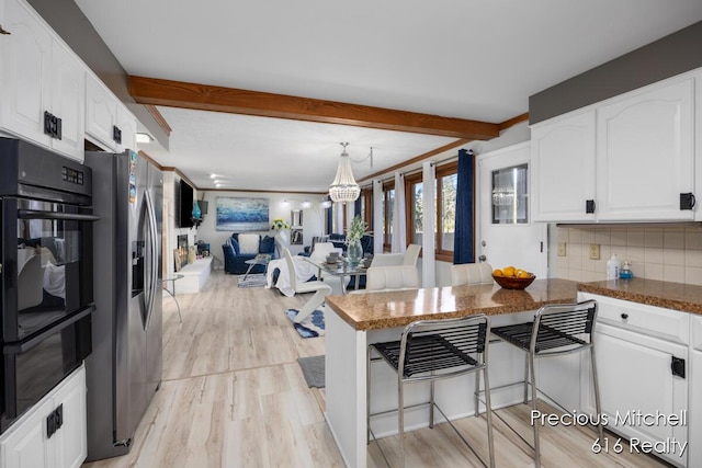 kitchen featuring stainless steel fridge with ice dispenser, white cabinetry, and beam ceiling