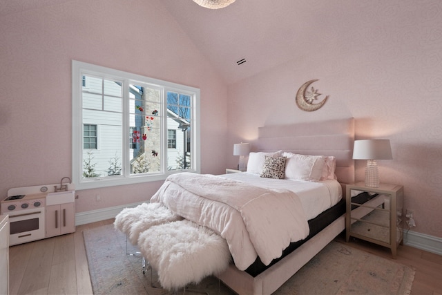 bedroom featuring baseboards, lofted ceiling, and light wood-type flooring