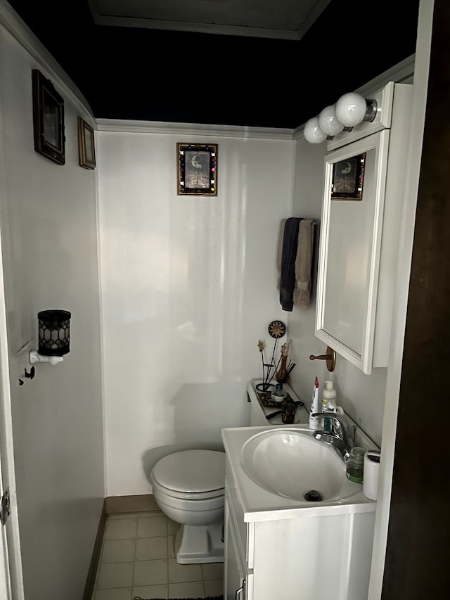 half bath with baseboards, toilet, tile patterned flooring, and vanity
