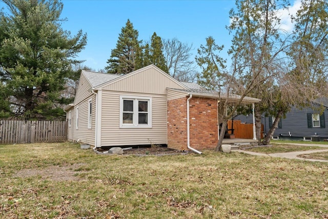 view of front of home with fence and a front lawn