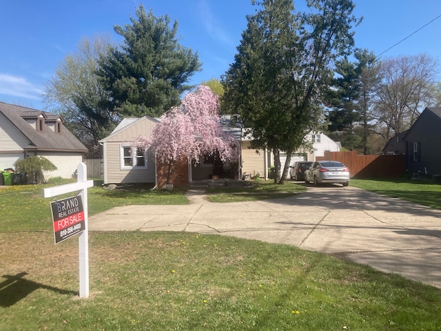 view of front of house with a front lawn, fence, and concrete driveway