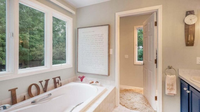 full bathroom with vanity, a garden tub, and a wealth of natural light