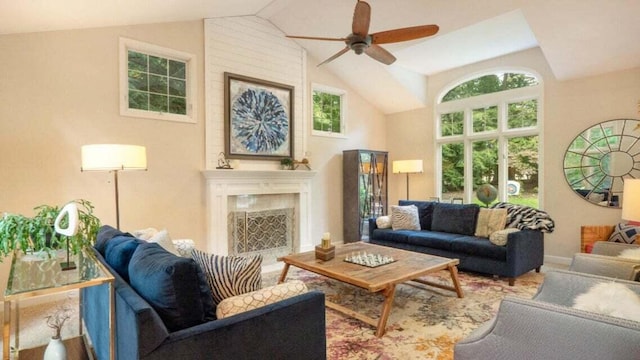 living room featuring a ceiling fan, high vaulted ceiling, and a fireplace
