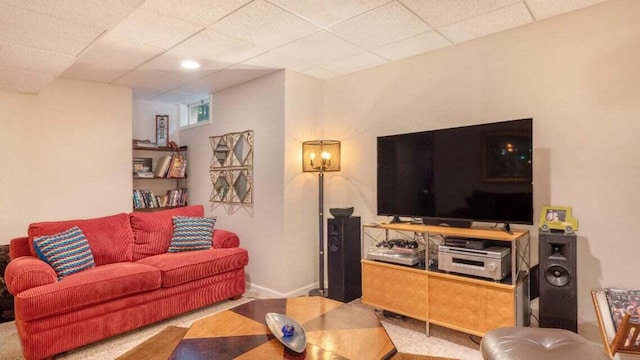 carpeted living room featuring baseboards and a paneled ceiling
