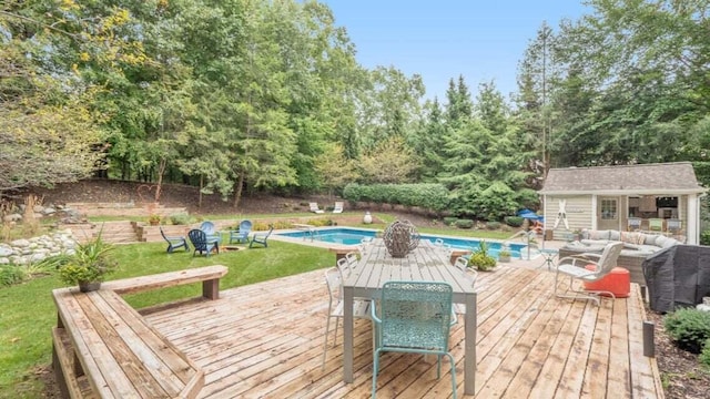wooden terrace with an outdoor structure, outdoor dining area, an exterior structure, an outdoor pool, and a yard