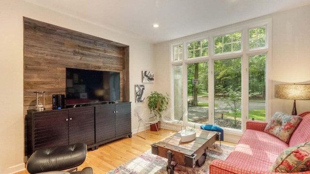living room featuring recessed lighting, baseboards, a healthy amount of sunlight, and light wood-style floors