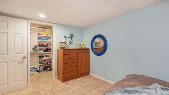 carpeted bedroom featuring recessed lighting, a drop ceiling, a walk in closet, and a closet