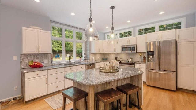 3820 Harbor Point Dr, Norton Shores, MI 49441 - kitchen with backsplash, stainless steel appliances, a breakfast bar, and light stone counters