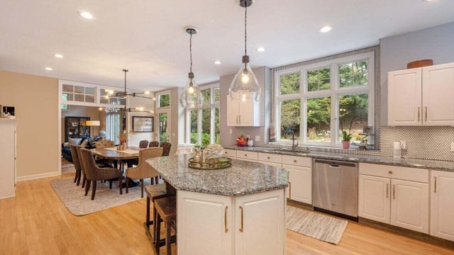 kitchen with stainless steel dishwasher, a sink, recessed lighting, and tasteful backsplash