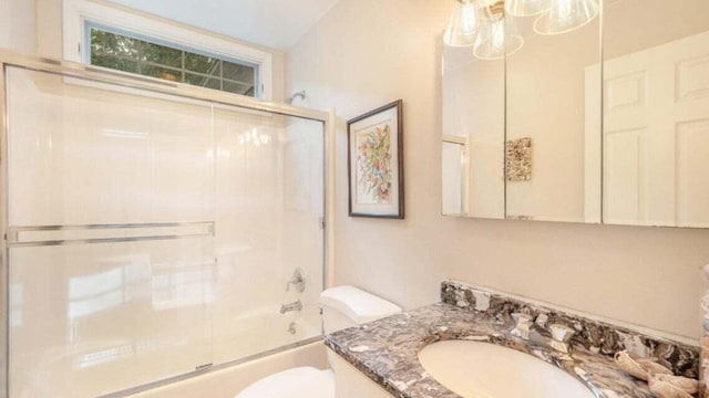 bathroom with vanity, combined bath / shower with glass door, and toilet