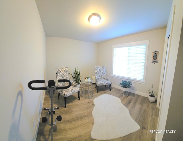 sitting room with baseboards and wood finished floors