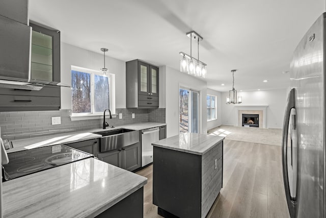 kitchen featuring a sink, light wood-type flooring, gray cabinetry, and appliances with stainless steel finishes