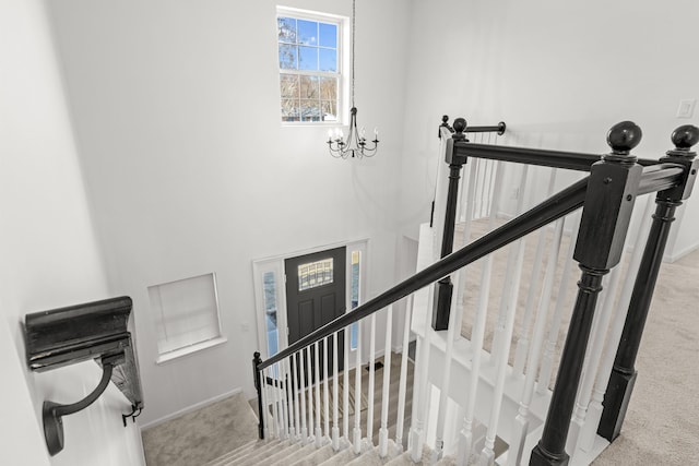 stairs with baseboards, carpet, and an inviting chandelier