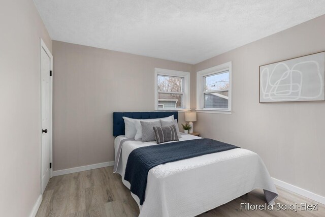2100 Dawson Ave NE, Grand Rapids, MI 49505 - bedroom with baseboards, wood finished floors, and a textured ceiling