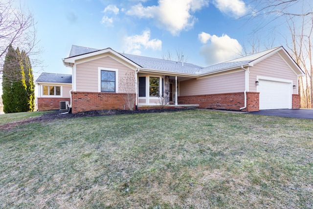 1405 S Sashabaw Rd, Ortonville, MI 48462 - ranch-style house with a front yard, a garage, brick siding, and aphalt driveway