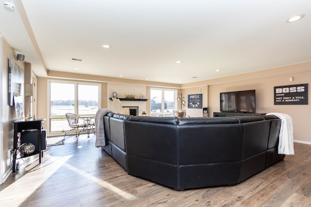 1405 S Sashabaw Rd, Ortonville, MI 48462 - living area with light wood finished floors, a wealth of natural light, and a large fireplace