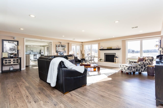 1405 S Sashabaw Rd, Ortonville, MI 48462 - living room with visible vents, wood finished floors, recessed lighting, and a brick fireplace