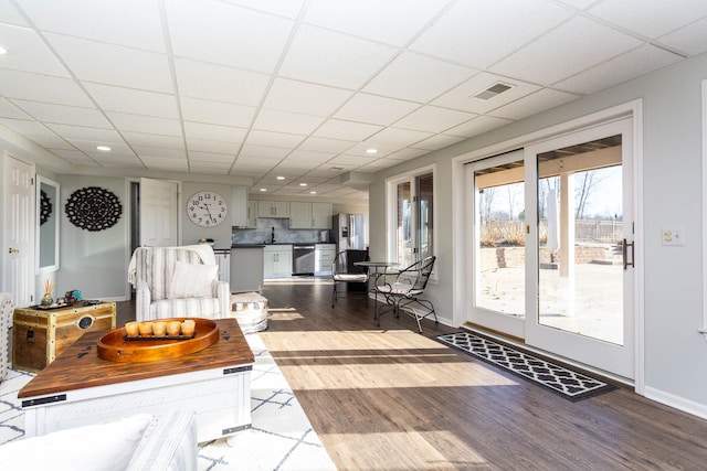 1405 S Sashabaw Rd, Ortonville, MI 48462 - living room featuring a paneled ceiling, wood finished floors, baseboards, and visible vents