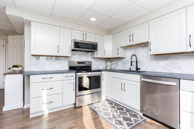 1405 S Sashabaw Rd, Ortonville, MI 48462 - kitchen featuring a sink, dark countertops, appliances with stainless steel finishes, and wood finished floors