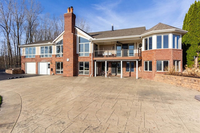 1405 S Sashabaw Rd, Ortonville, MI 48462 - rear view of house with a balcony, a chimney, an attached garage, and brick siding