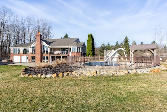 1405 S Sashabaw Rd, Ortonville, MI 48462 - exterior space featuring fence, a lawn, brick siding, a garage, and a chimney