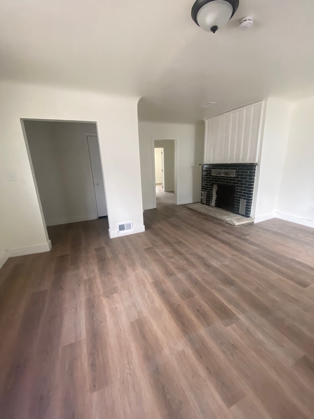 unfurnished living room with baseboards, dark wood-style flooring, and visible vents