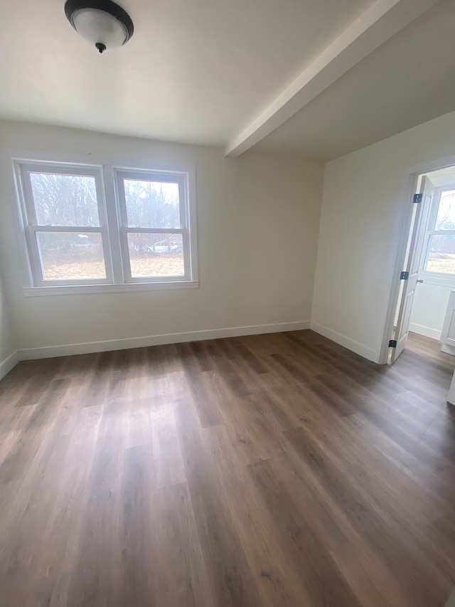 unfurnished room featuring baseboards and dark wood-style floors