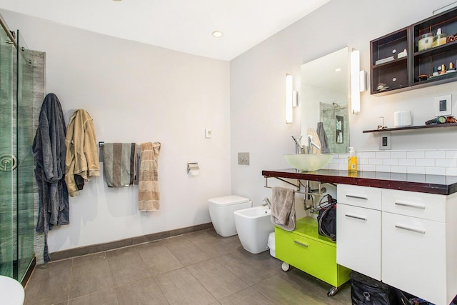 bathroom with toilet, baseboards, a shower stall, tile patterned floors, and a bidet