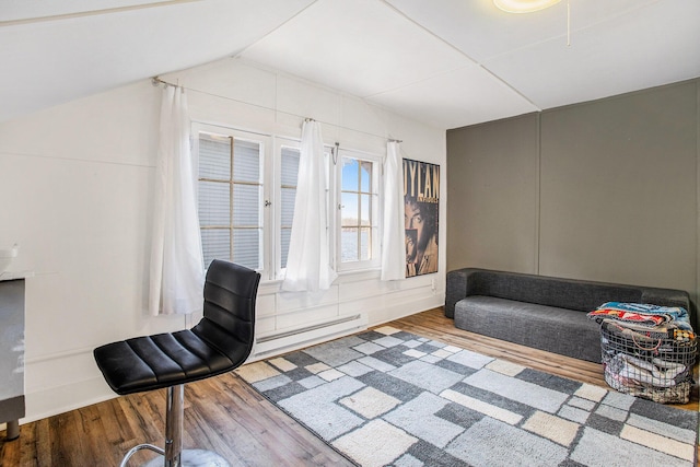 sitting room featuring wood finished floors, vaulted ceiling, and a baseboard radiator